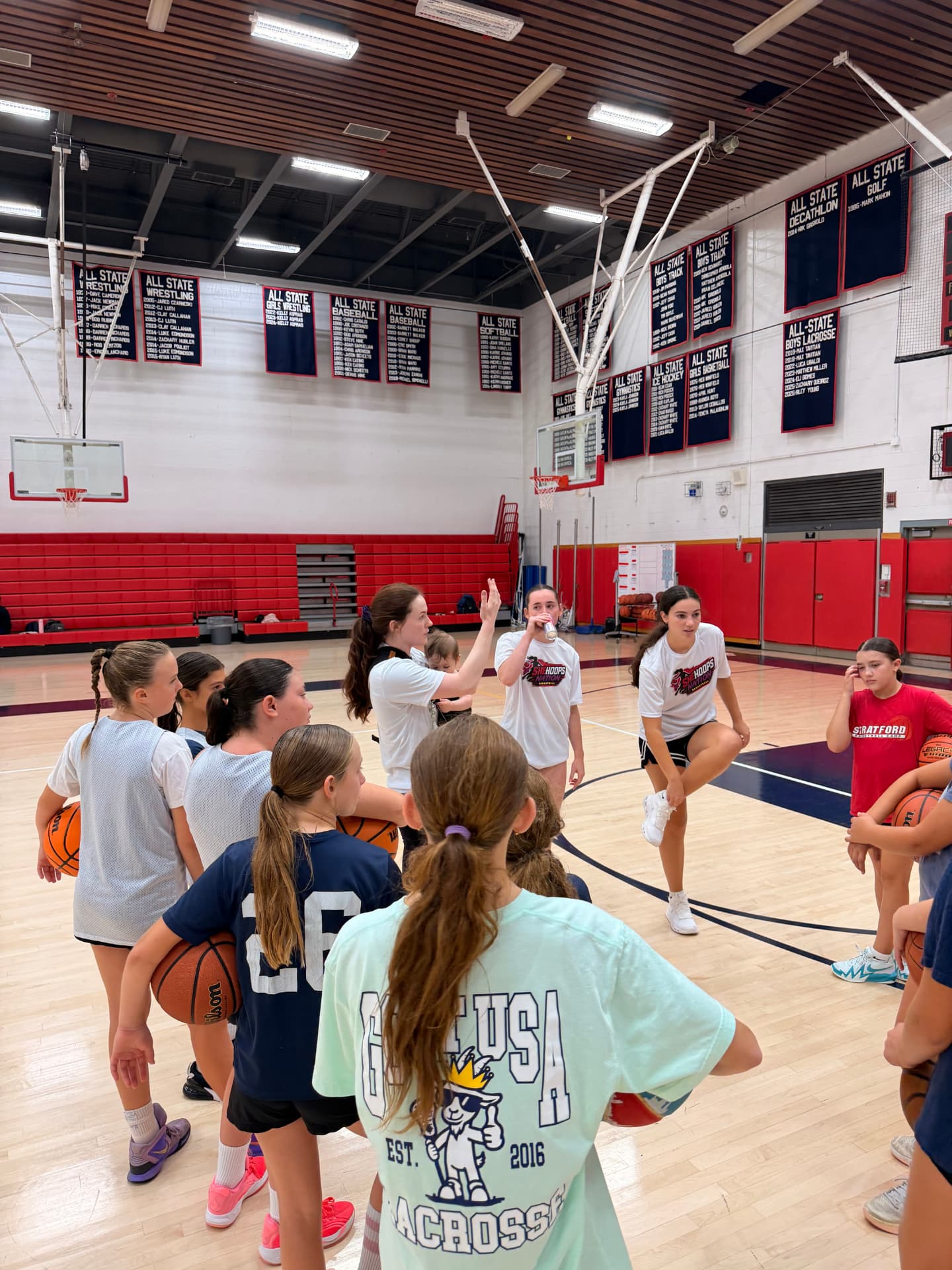 Players lined up with basketballs during a drill